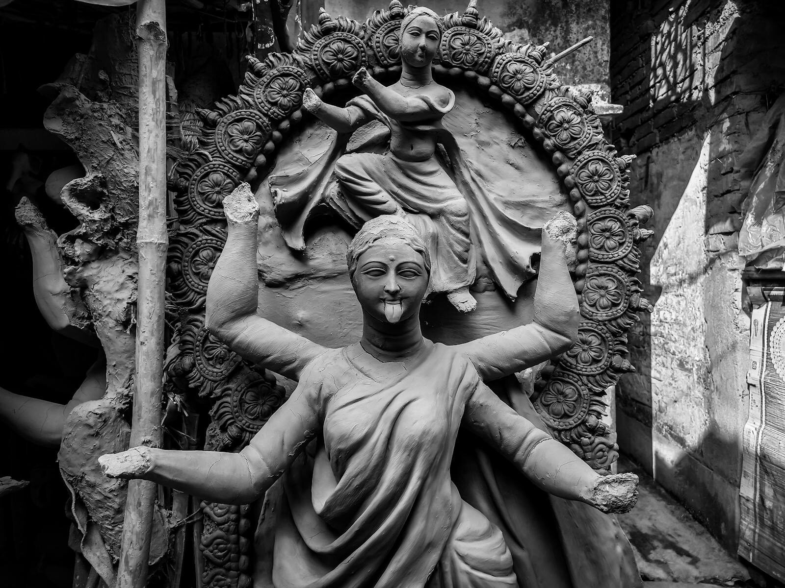 Black and white photo of clay sculptures of Hindu goddess Kali in Kolkata, capturing artistry and culture.
