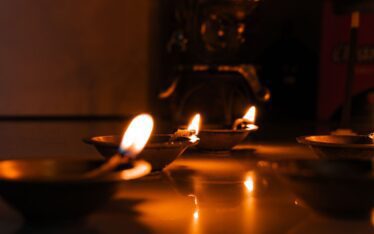 Close-up of traditional diyas lit for Diwali celebration in India, showcasing cultural heritage and warm ambiance.
